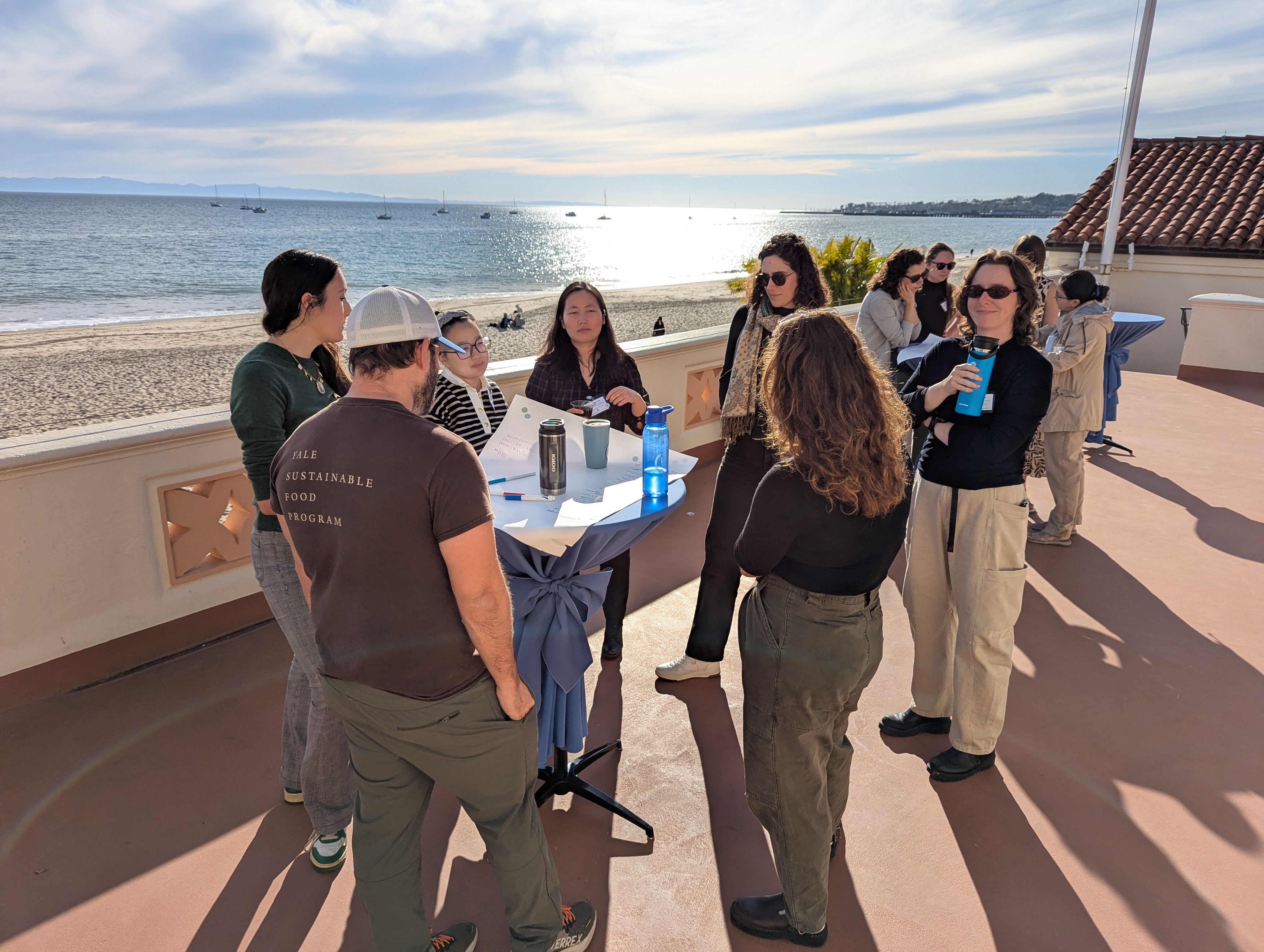 group of people outside standing at a table