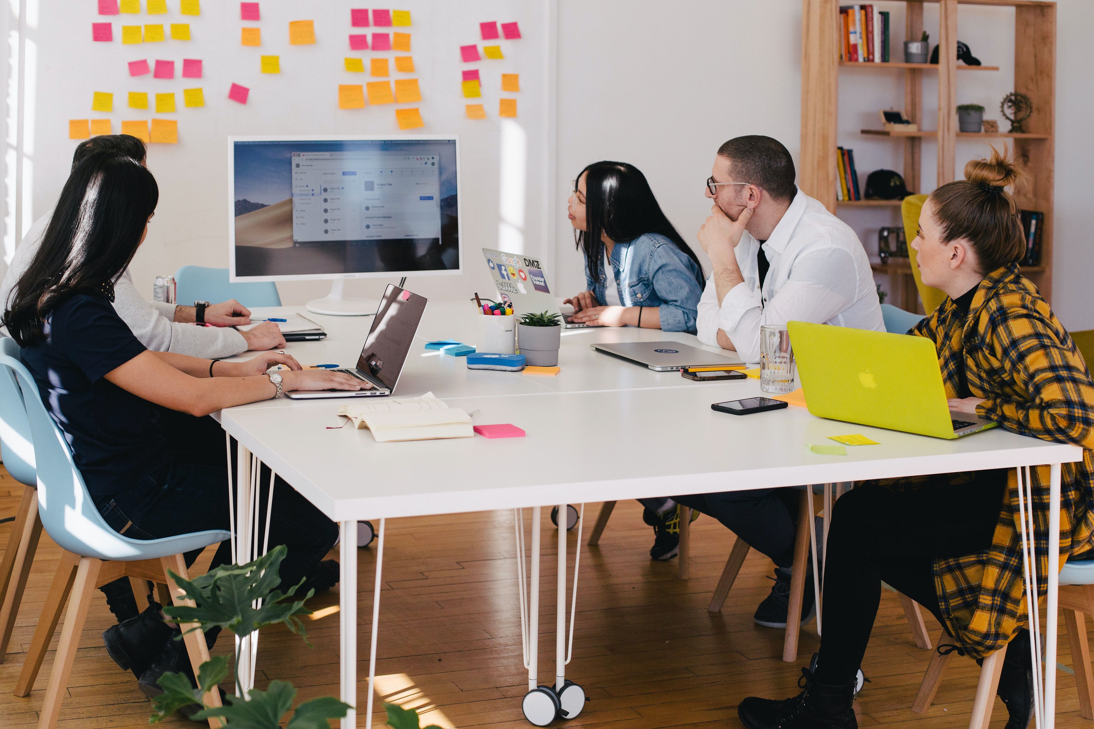 Group coworking together and looking at a monitor