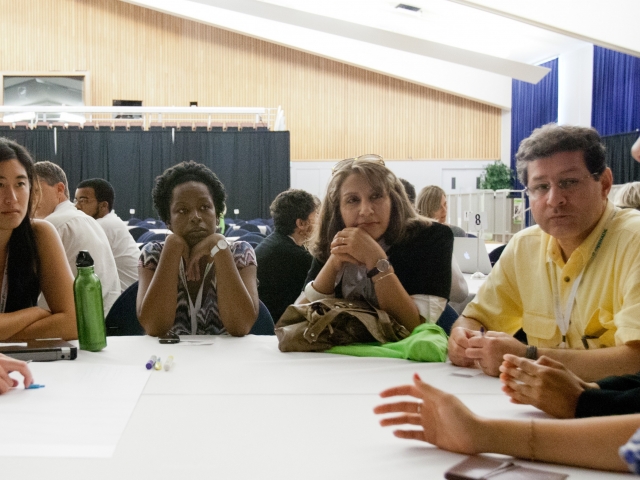 Group of people sitting around table having a discussion