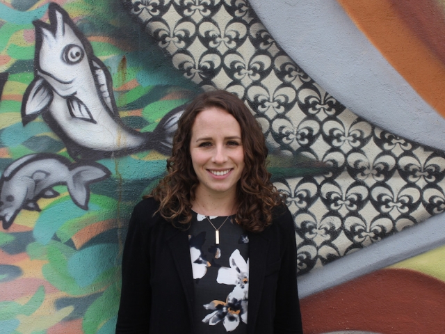 lady standing in front of wall mural