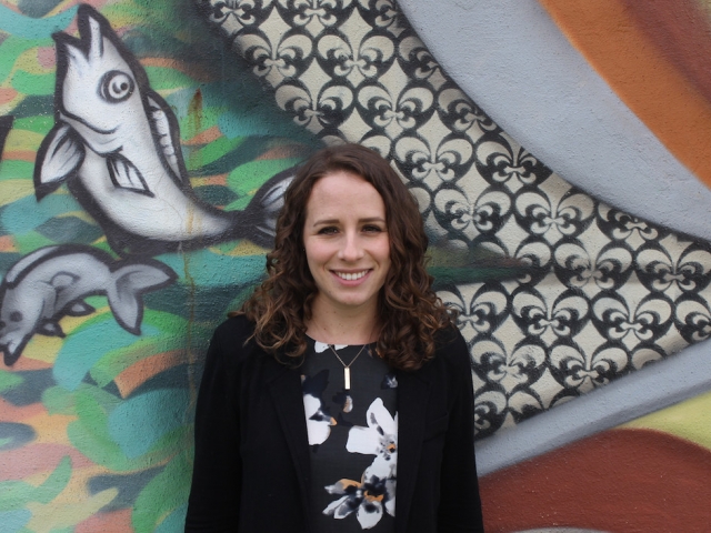 lady standing in front of wall mural