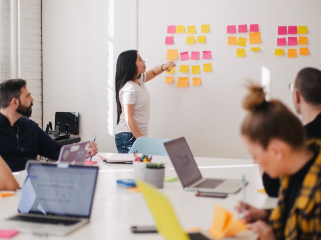 person at whiteboard with sticky notes