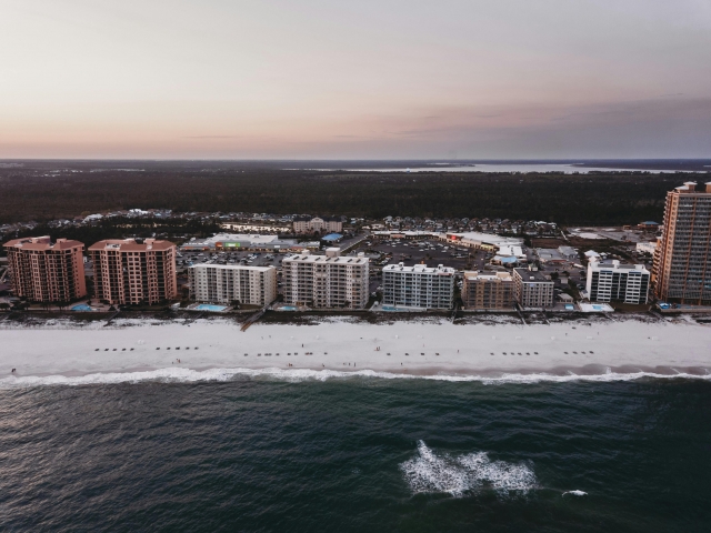 multiple story buildings along the coastline at sunset
