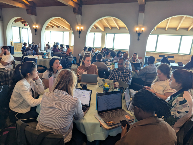 group of people in a room working at tables