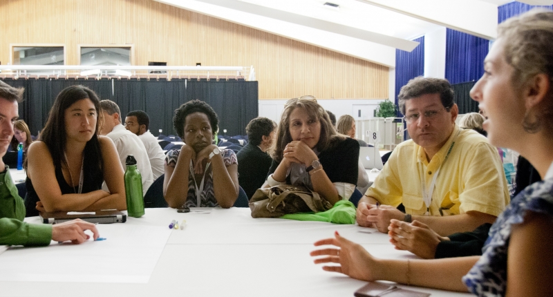 Group of people sitting around table having a discussion