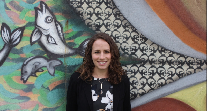 lady standing in front of wall mural