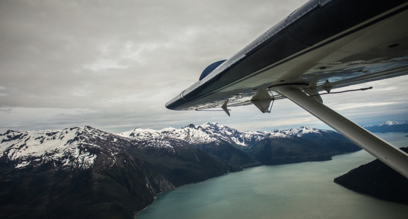 Plane wing over Alaskan fjord
