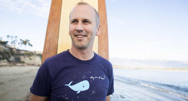 Ben Halpern standing with surf board on beach