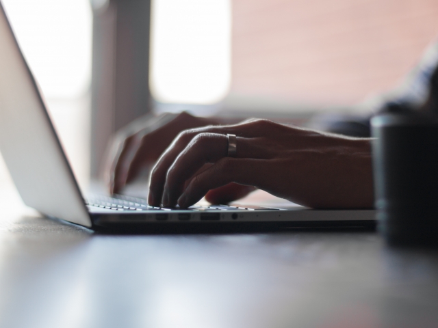 Hands typing on laptop